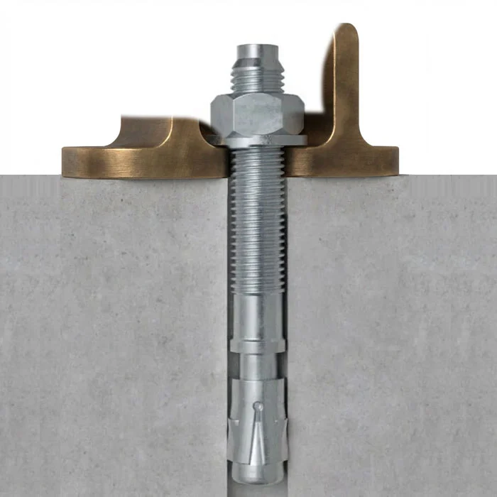 Wedge anchor bolt set in concrete through a steel bracket