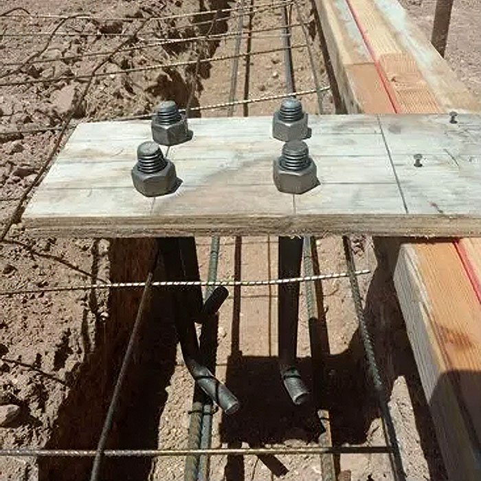 Cast-in anchor bolts set in a footing with a wooden template